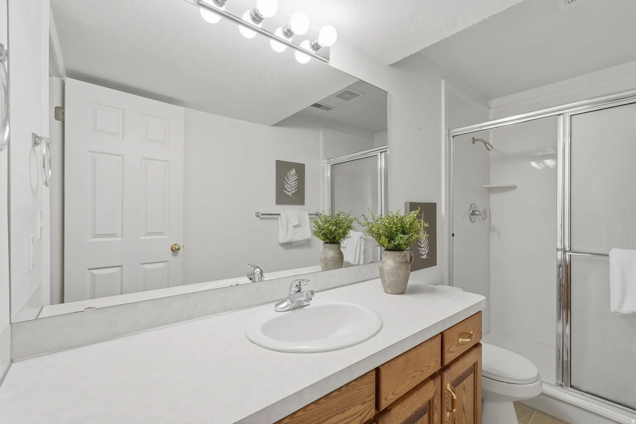 Full bath featuring a stall shower and vanity