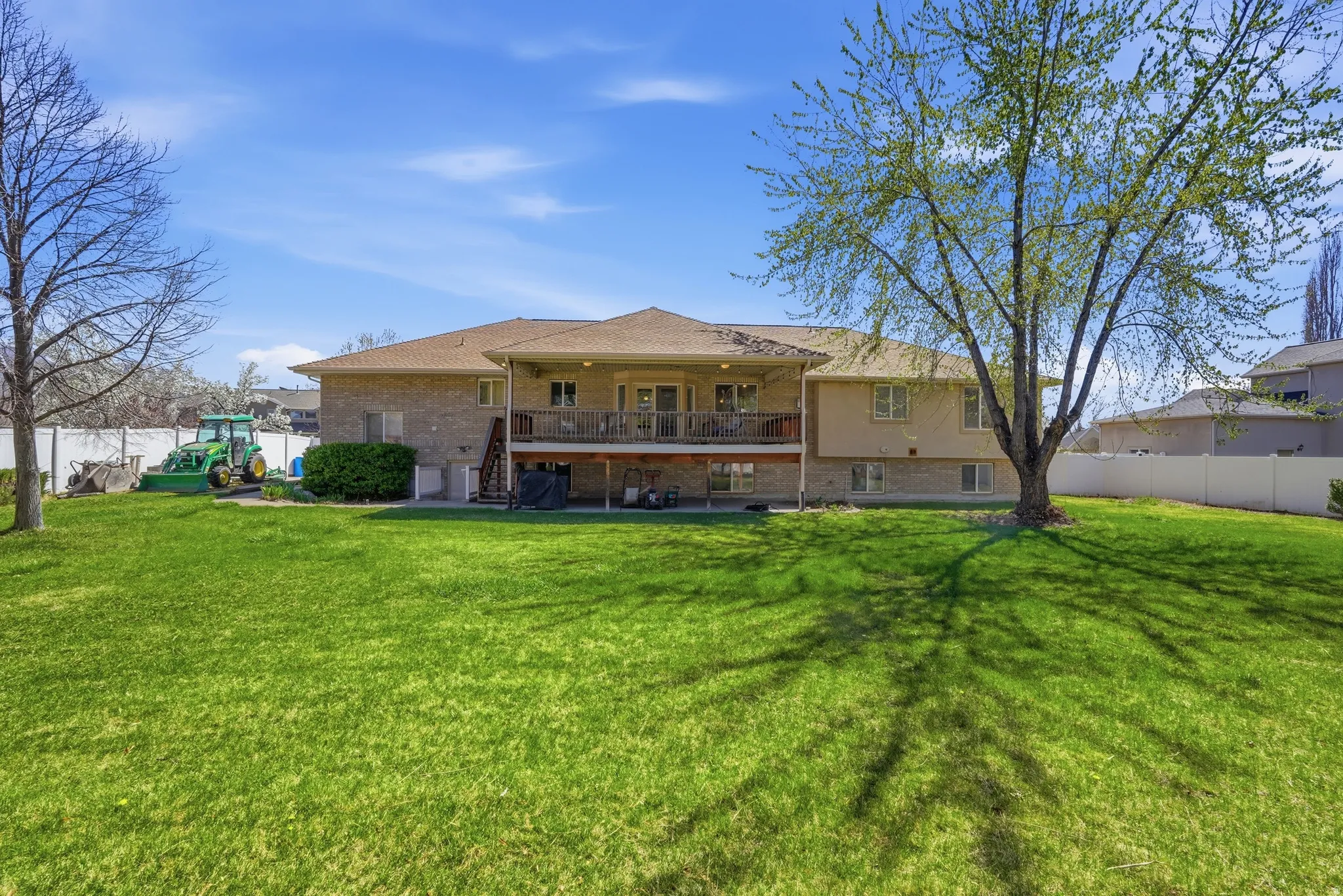 Back of property with a fenced backyard, brick siding, a patio, and a balcony