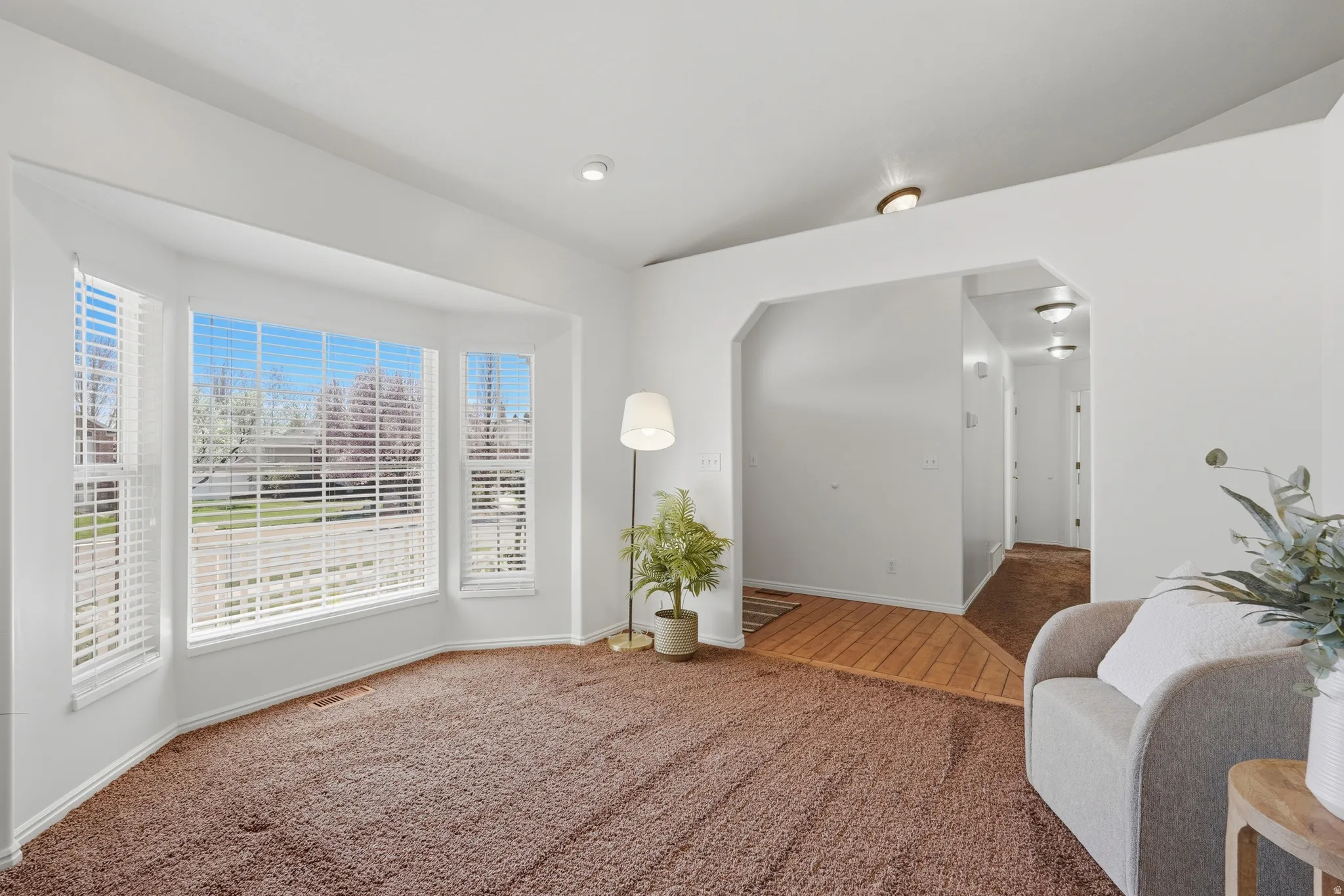 Sitting room featuring arched walkways, carpet, and lofted ceiling