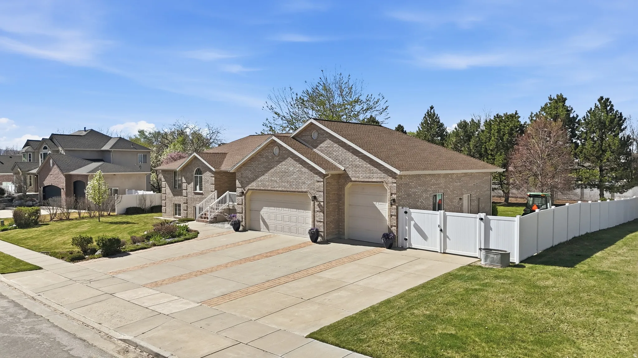 View of front facade with a gate, concrete driveway, a garage, brick siding, and a shingled roof