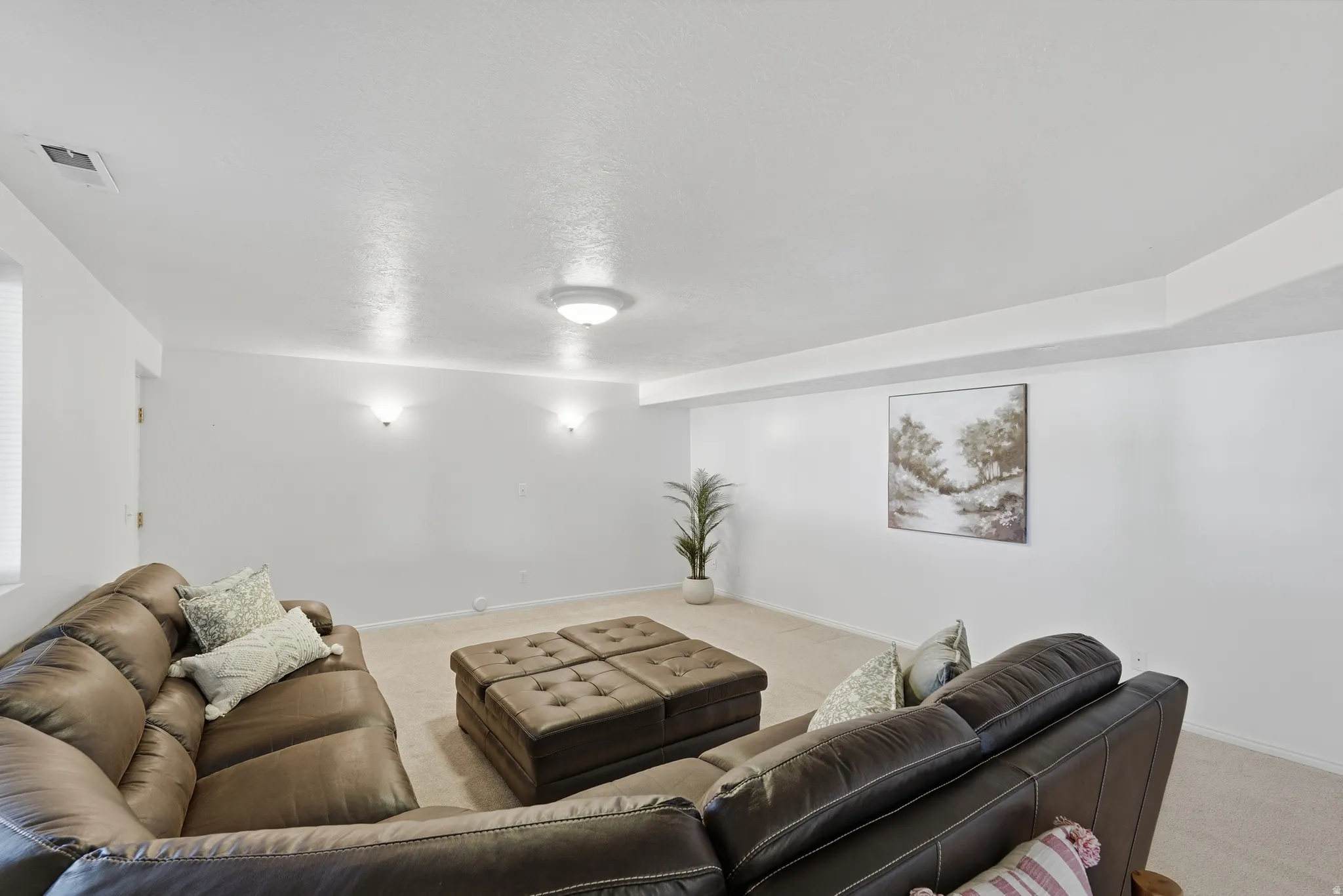 Living area featuring light colored carpet and a textured ceiling