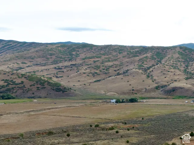 Expansive land with paved roads, scattered natural vegetation, and distant mountain ranges