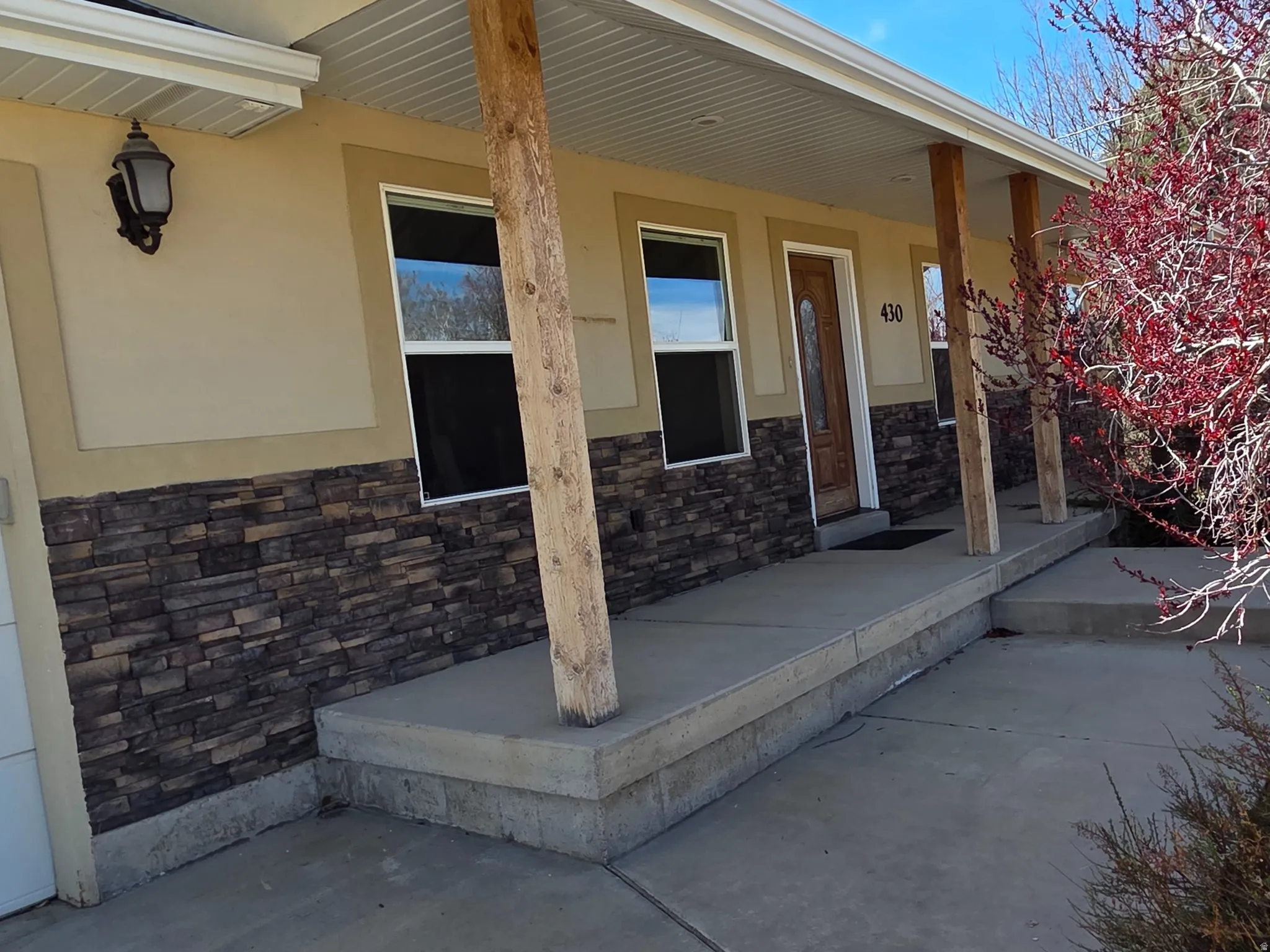 View of front porch entry with stone and stucco siding