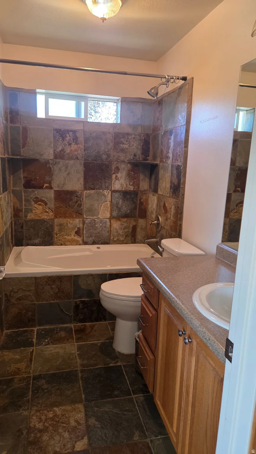 Master Bathroom (#2) featuring vanity, stone tile floors, and tiled shower / bath combo