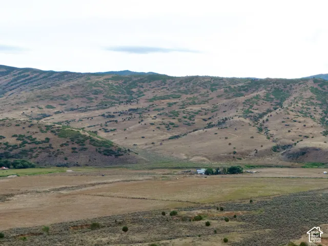 Expansive landscape featuring distant mountains, natural vegetation, and paved roads