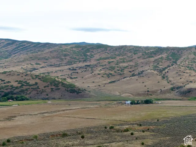 Expansive land with paved roads, scattered natural vegetation, and distant mountain ranges