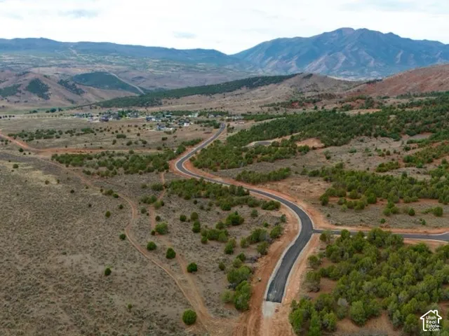 Expansive landscape featuring distant mountains, established community, and paved roads with cul-de-sac