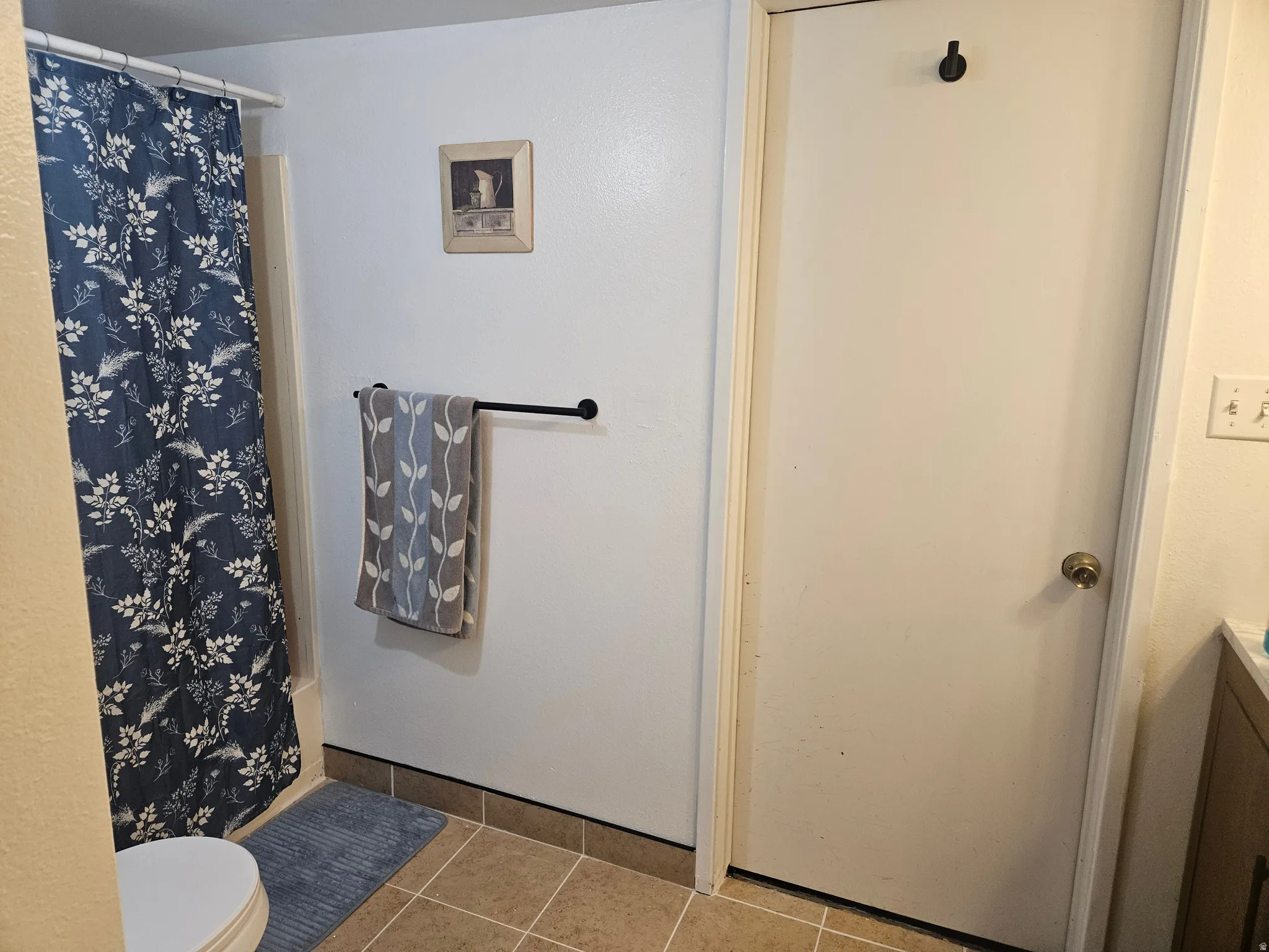 Full bathroom featuring light tile patterned floors and vanity
