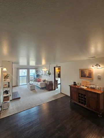 Bedroom with a textured ceiling and dark wood-style floors