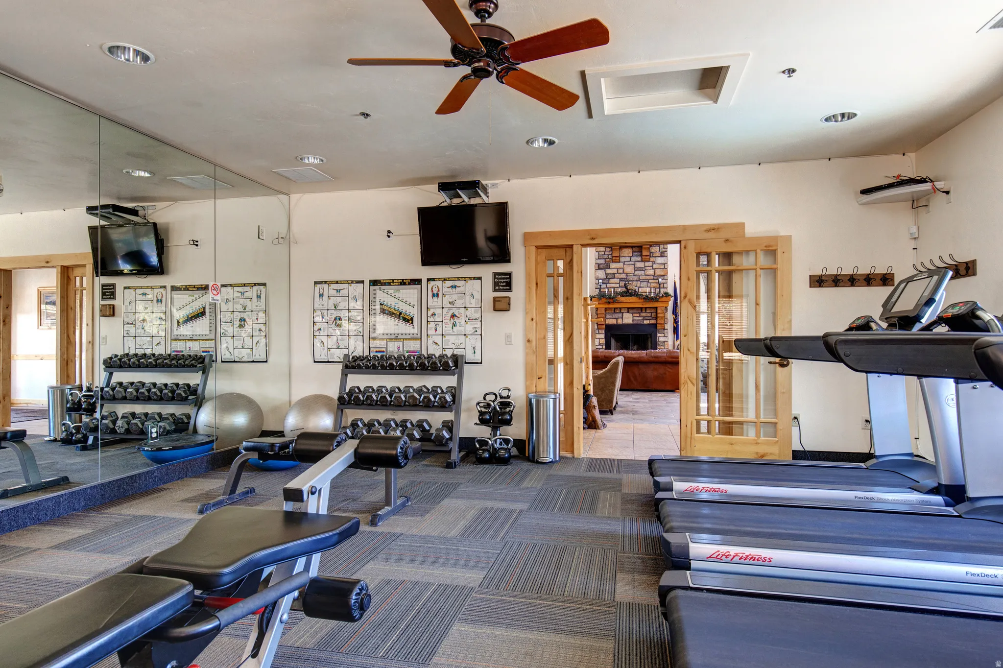 Gym with ceiling fan and recessed lighting