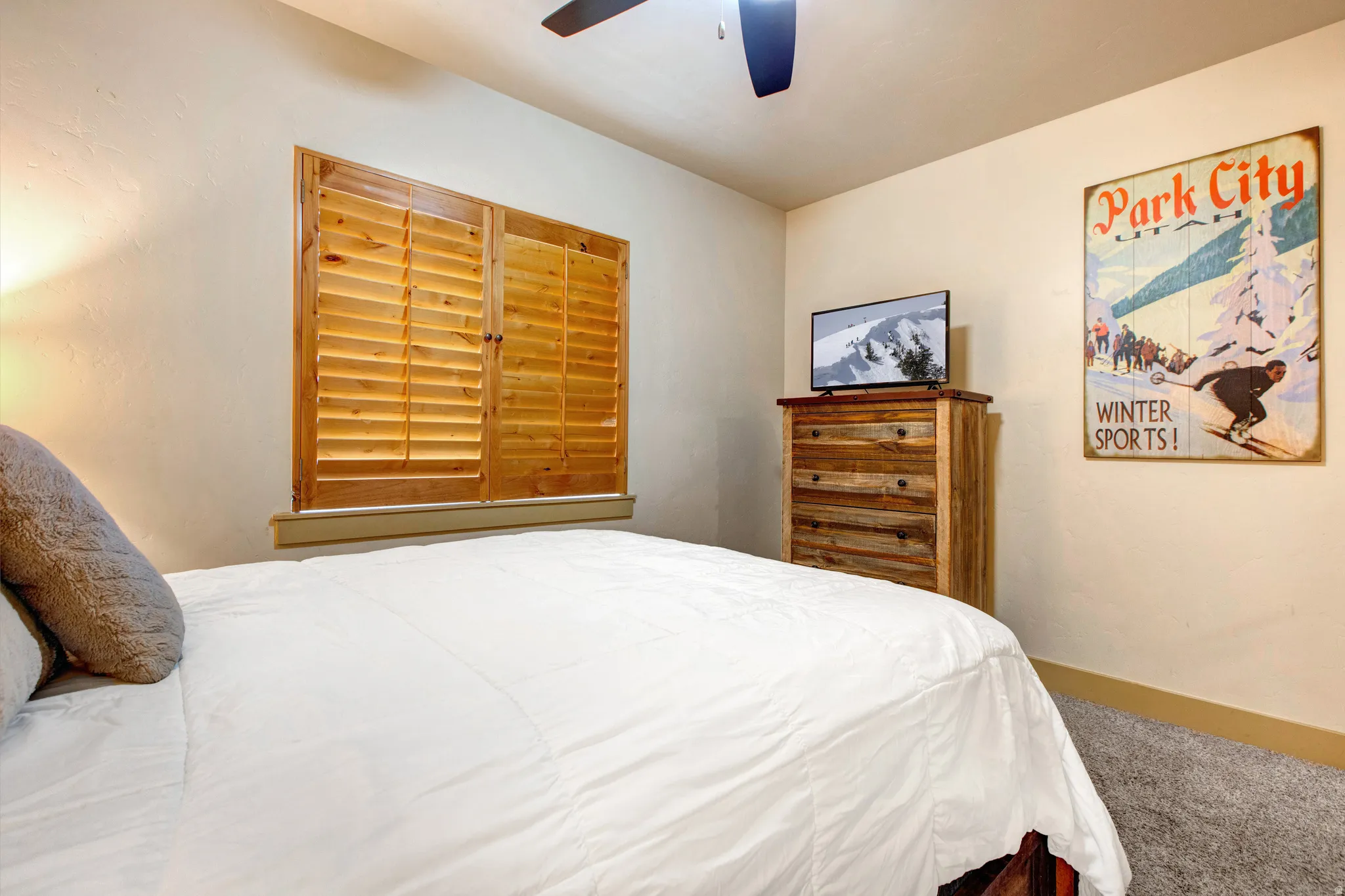 Carpeted bedroom featuring baseboards and ceiling fan