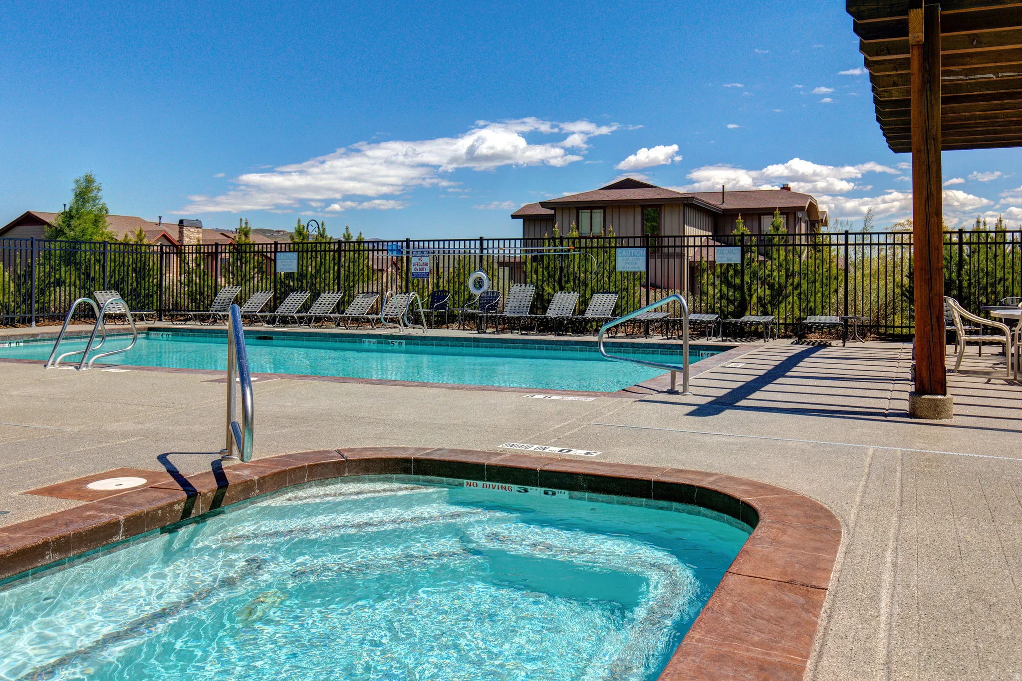Community pool with a patio area and a hot tub