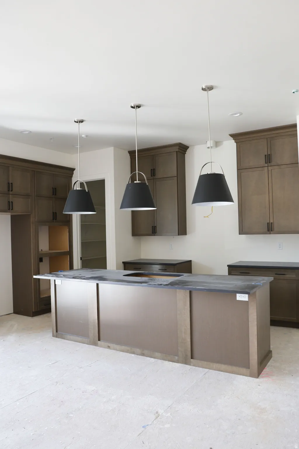 Kitchen featuring a kitchen island, hanging light fixtures, and dark wood finish cabinetry