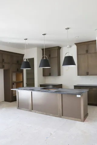 Kitchen featuring a kitchen island, hanging light fixtures, and dark wood finish cabinetry