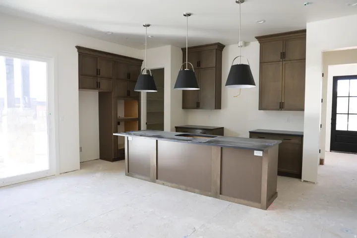 Kitchen with a kitchen island, decorative light fixtures, and dark wood finish cabinetry