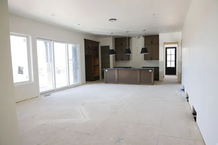 Kitchen featuring a center island, decorative light fixtures, open floor plan, dark countertops, and dark wood finish cabinets