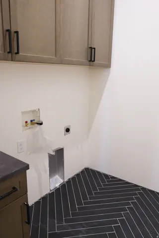 Laundry room featuring cabinet space, hookup for a washing machine, and electric dryer hookup