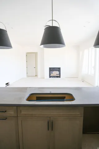 Kitchen with a glass covered fireplace, wood finish cabinets, light stone countertops, and open floor plan
