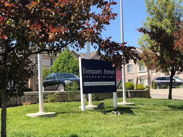 Community / neighborhood sign featuring a lawn