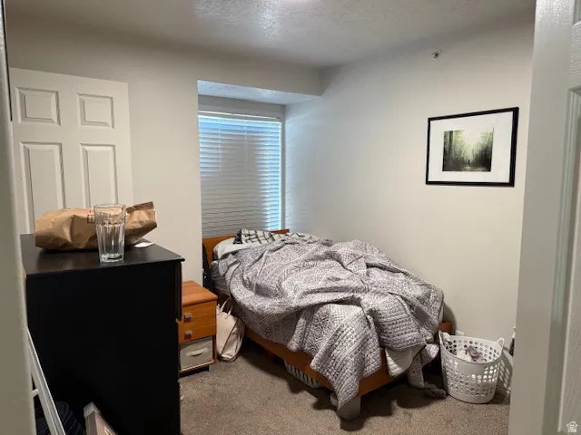 Bedroom featuring a textured ceiling and carpet flooring
