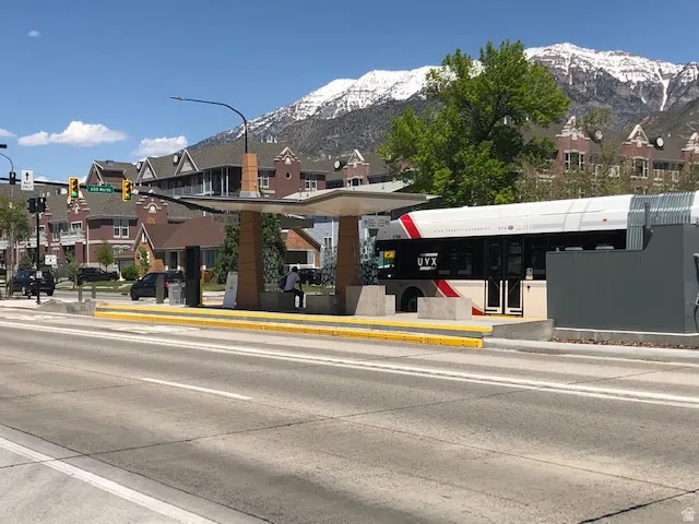 View of concrete road with sidewalks, traffic lights, curbs, and a mountain view