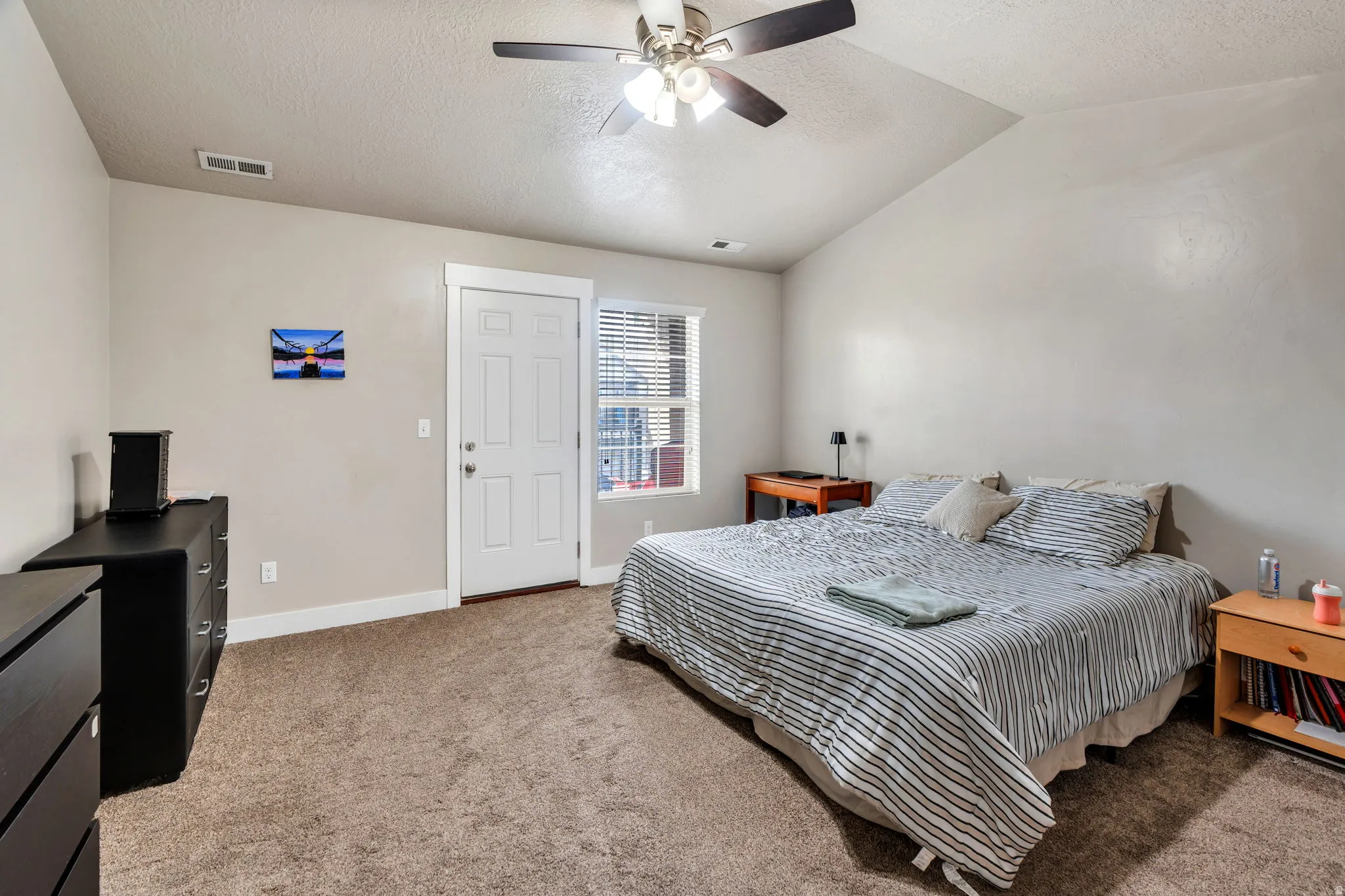 Bedroom with light colored carpet and a ceiling fan