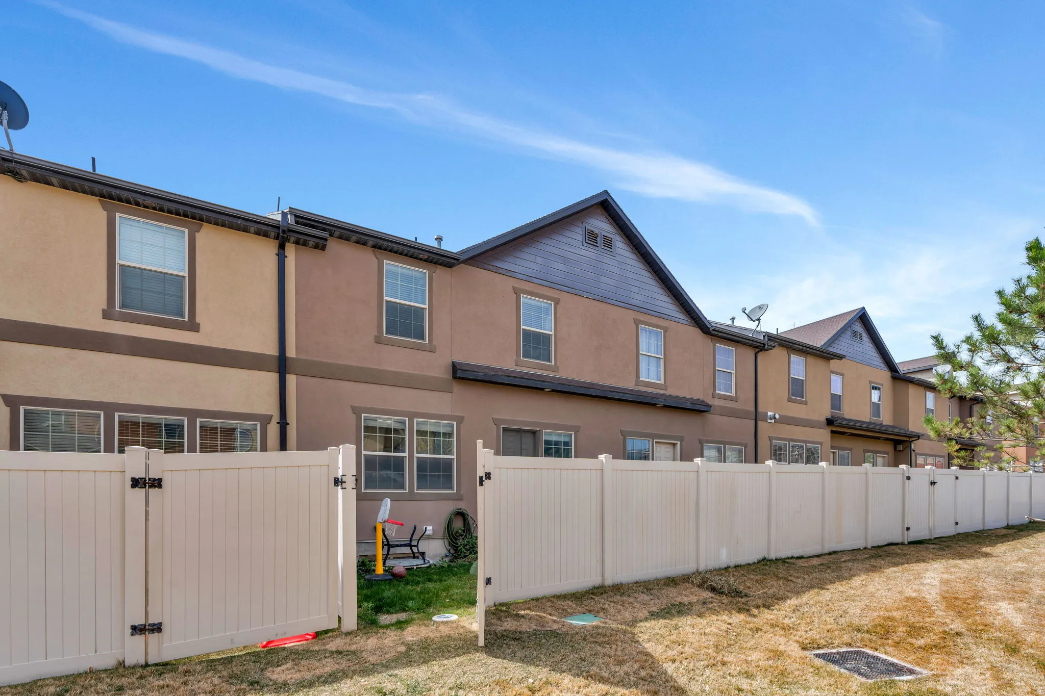 Back of house featuring a gate and stucco siding