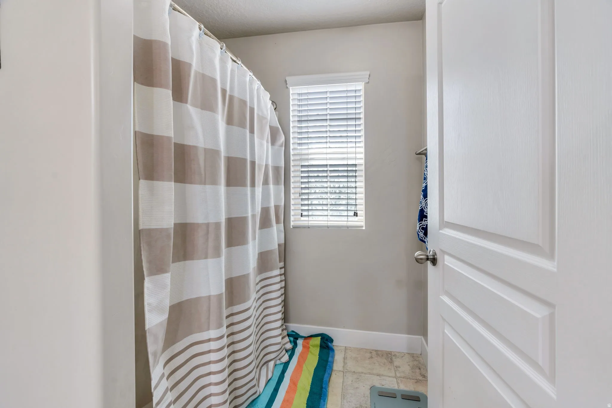 Bathroom featuring a shower with shower curtain and light tile patterned floors