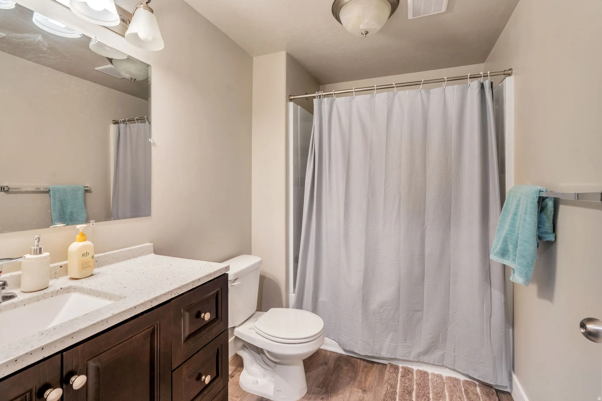 Bathroom featuring vanity, light wood-style floors, and curtained shower