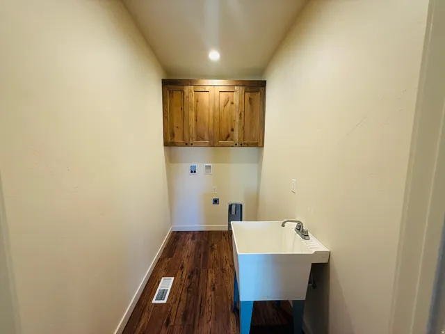 Laundry area with cabinet space, dark wood-style floors, hookup for a washing machine, and recessed lighting