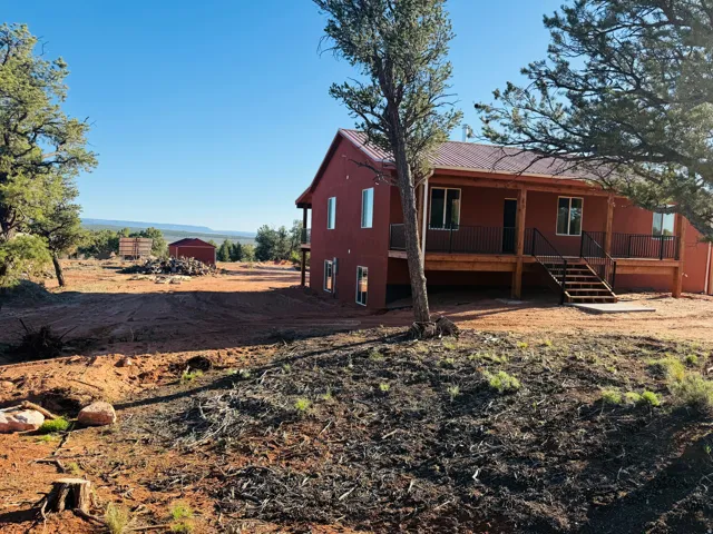 Rear view of property with stairs and a porch