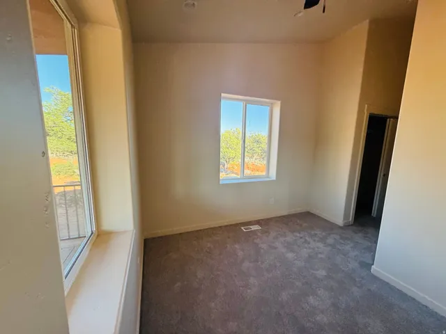Spare room with dark colored carpet and baseboards