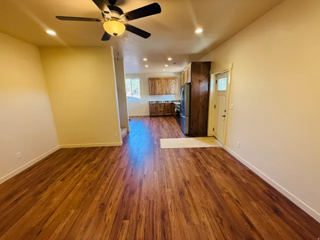 Kitchen with open floor plan, dark wood-type flooring, recessed lighting, a ceiling fan, and light countertops