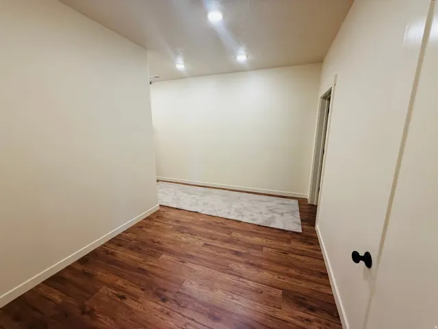 Spare room with dark wood finished floors and baseboards
