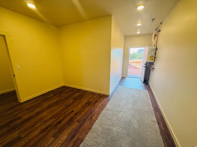 Corridor featuring dark wood-type flooring and recessed lighting