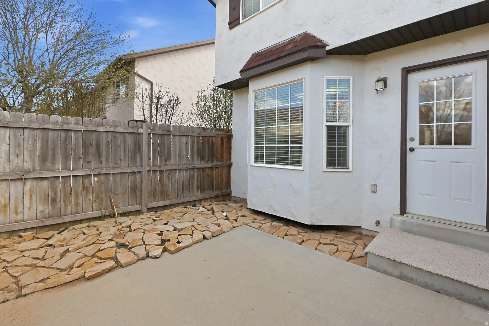 Back of Home With Large Patio and Bay Window