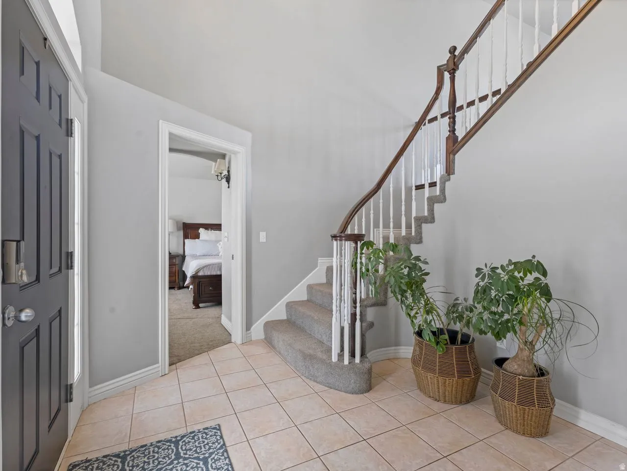 Foyer featuring stairs and light tile patterned flooring