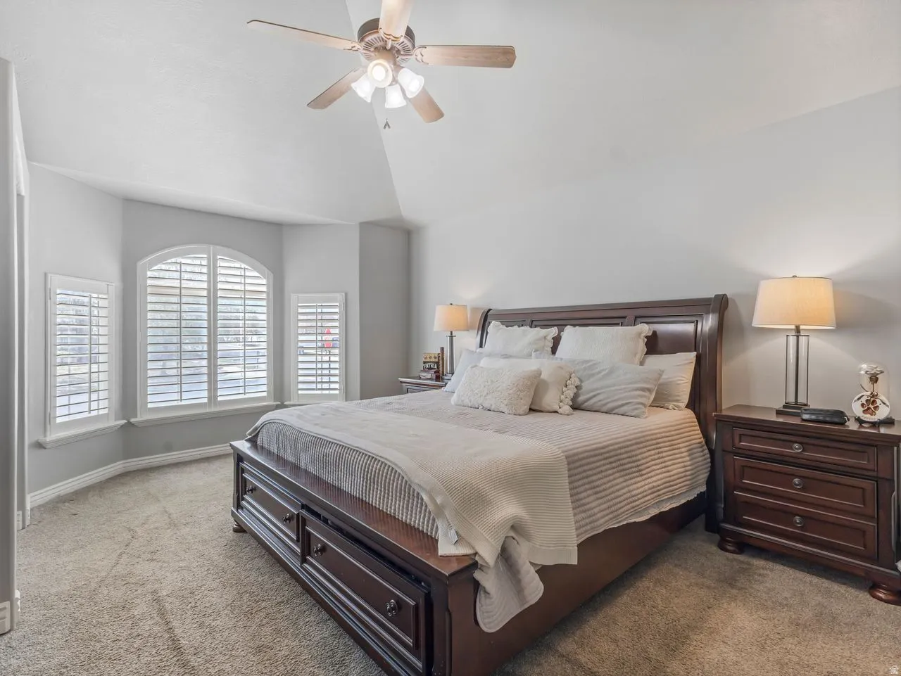 Bedroom featuring carpet floors, vaulted ceiling, and ceiling fan
