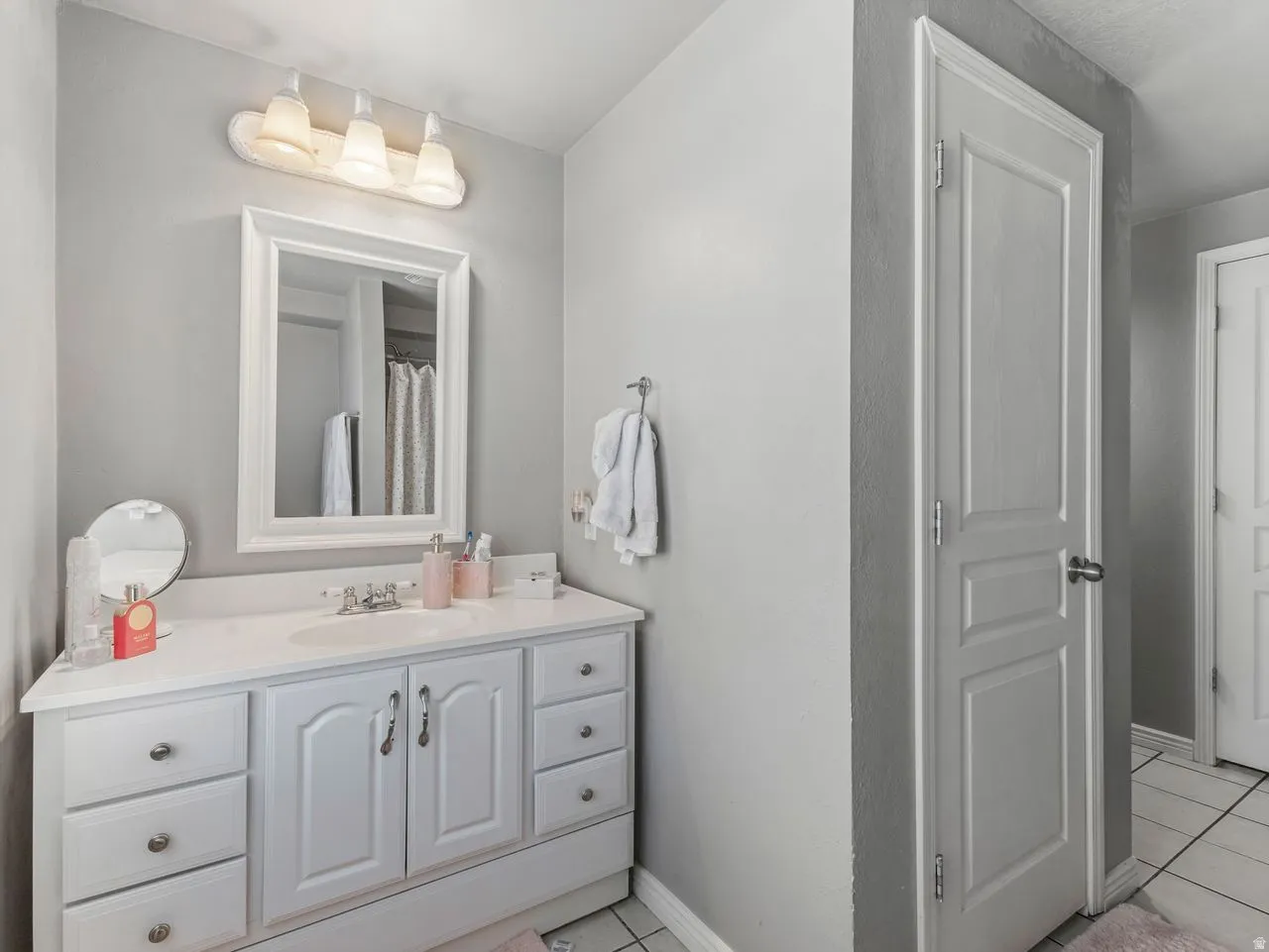 Bathroom with vanity, light tile patterned floors, and a shower with curtain