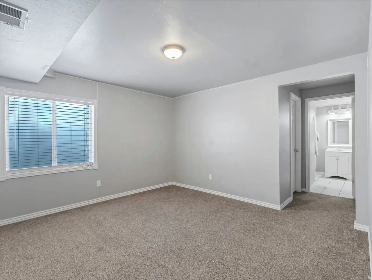 Spare room featuring carpet flooring and baseboards