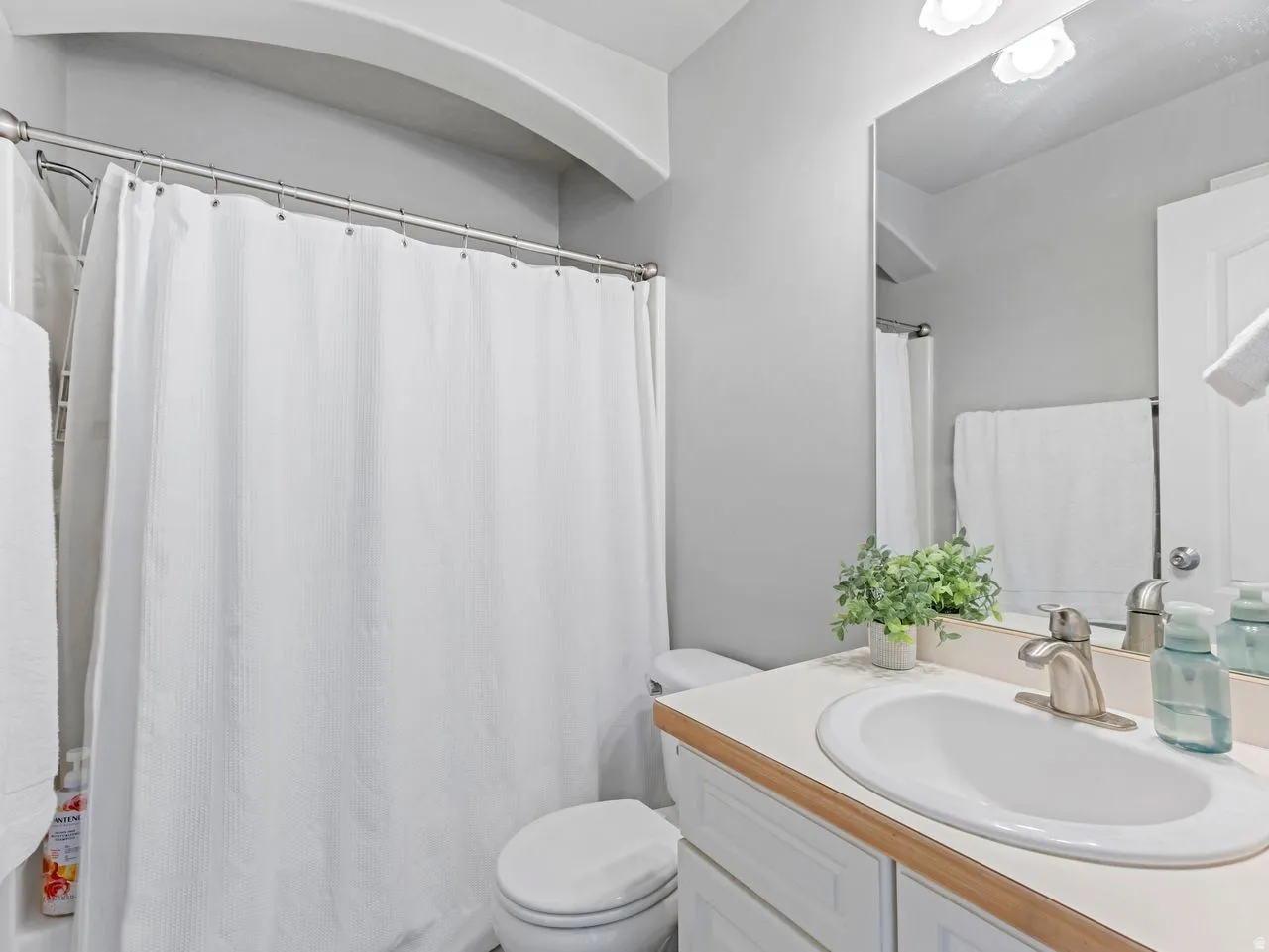 Full bath with vanity and a shower with shower curtain