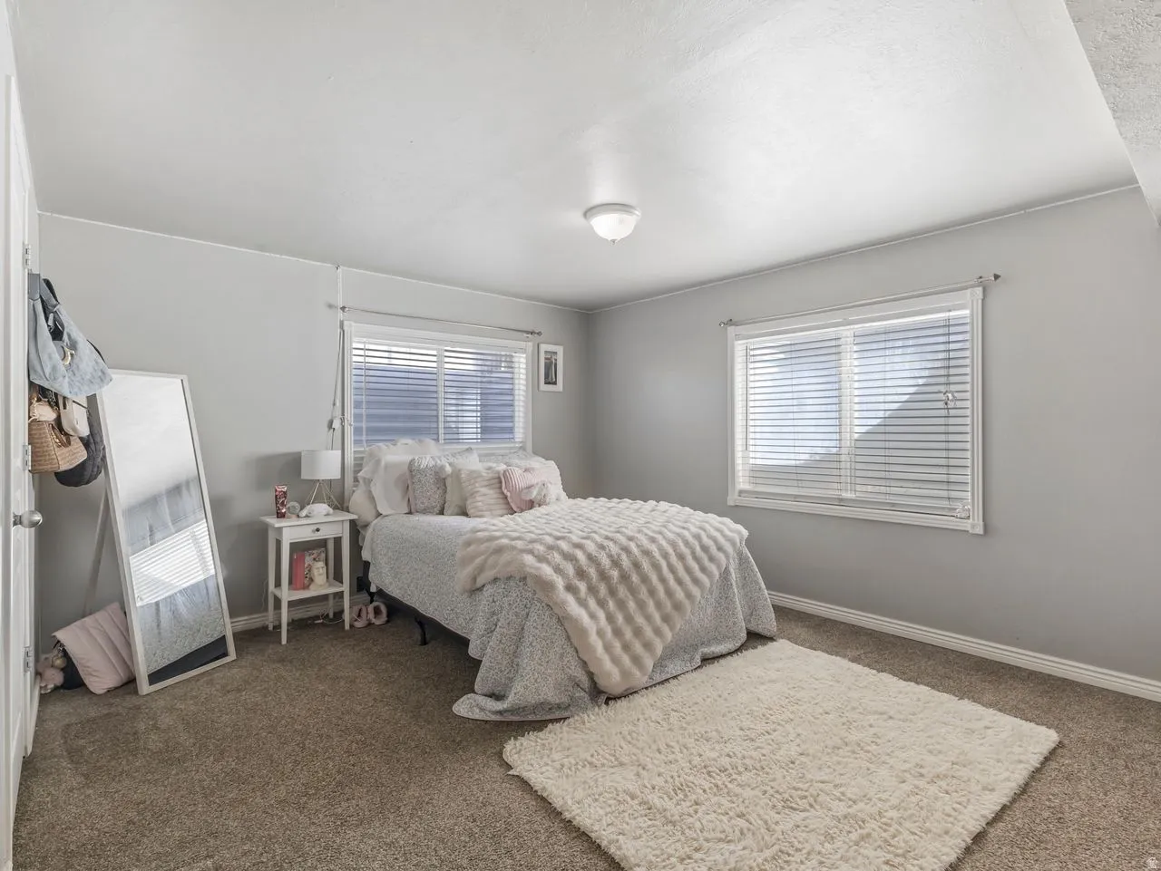 Bedroom featuring dark colored carpet and multiple windows