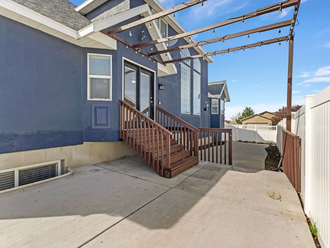 Entrance to property featuring roof with shingles, a patio area, and stucco siding