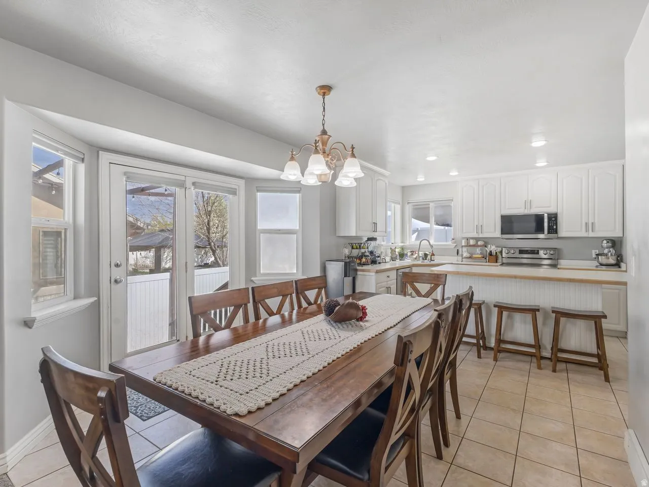 Dining area featuring light tile patterned floors and suspended lighting