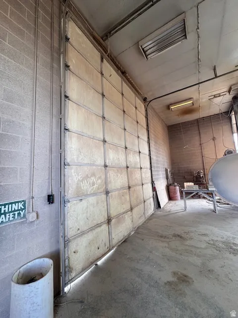 Garage featuring oil tank and concrete block wall