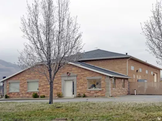 Ranch-style house featuring stone siding