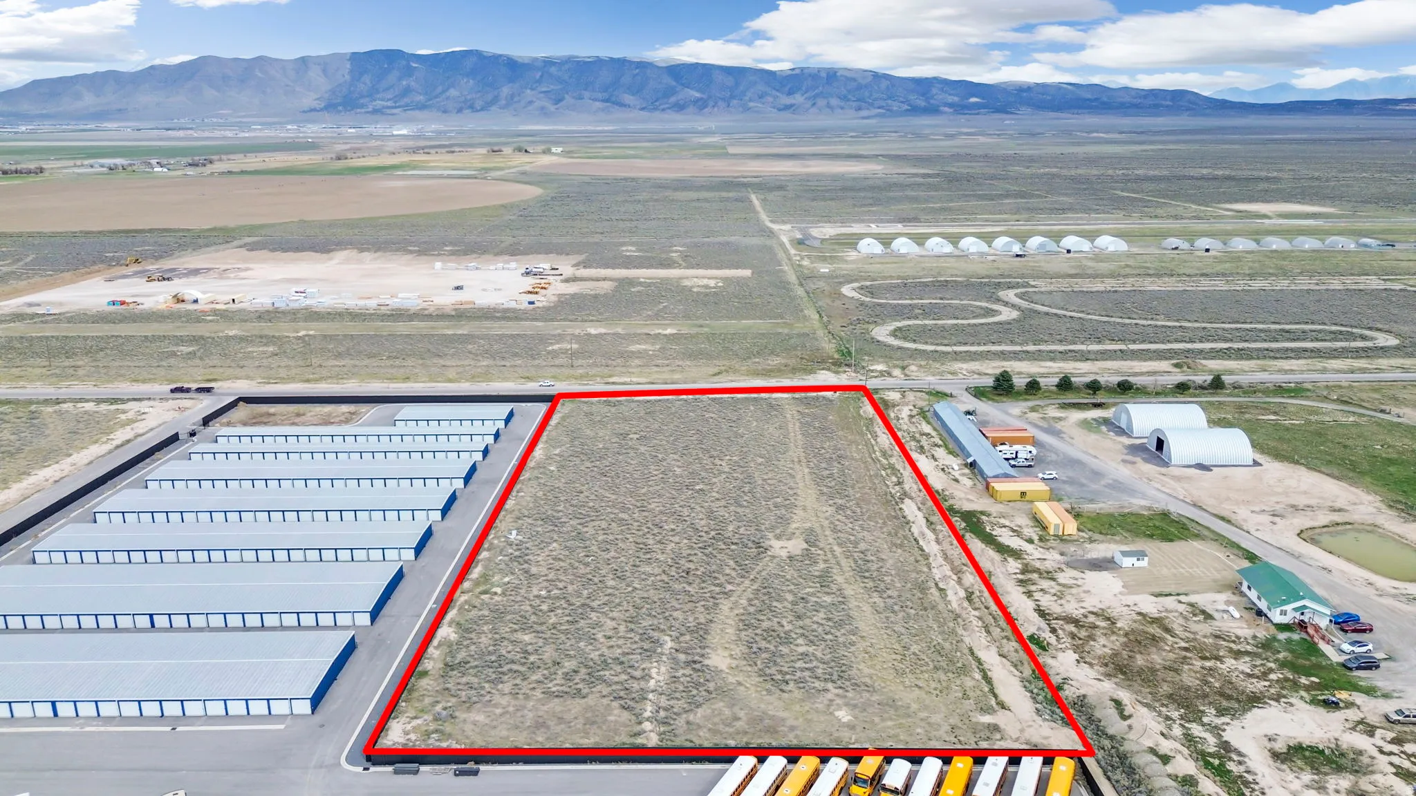 Aerial overview of property's location with a mountain backdrop and property boundaries highlighted