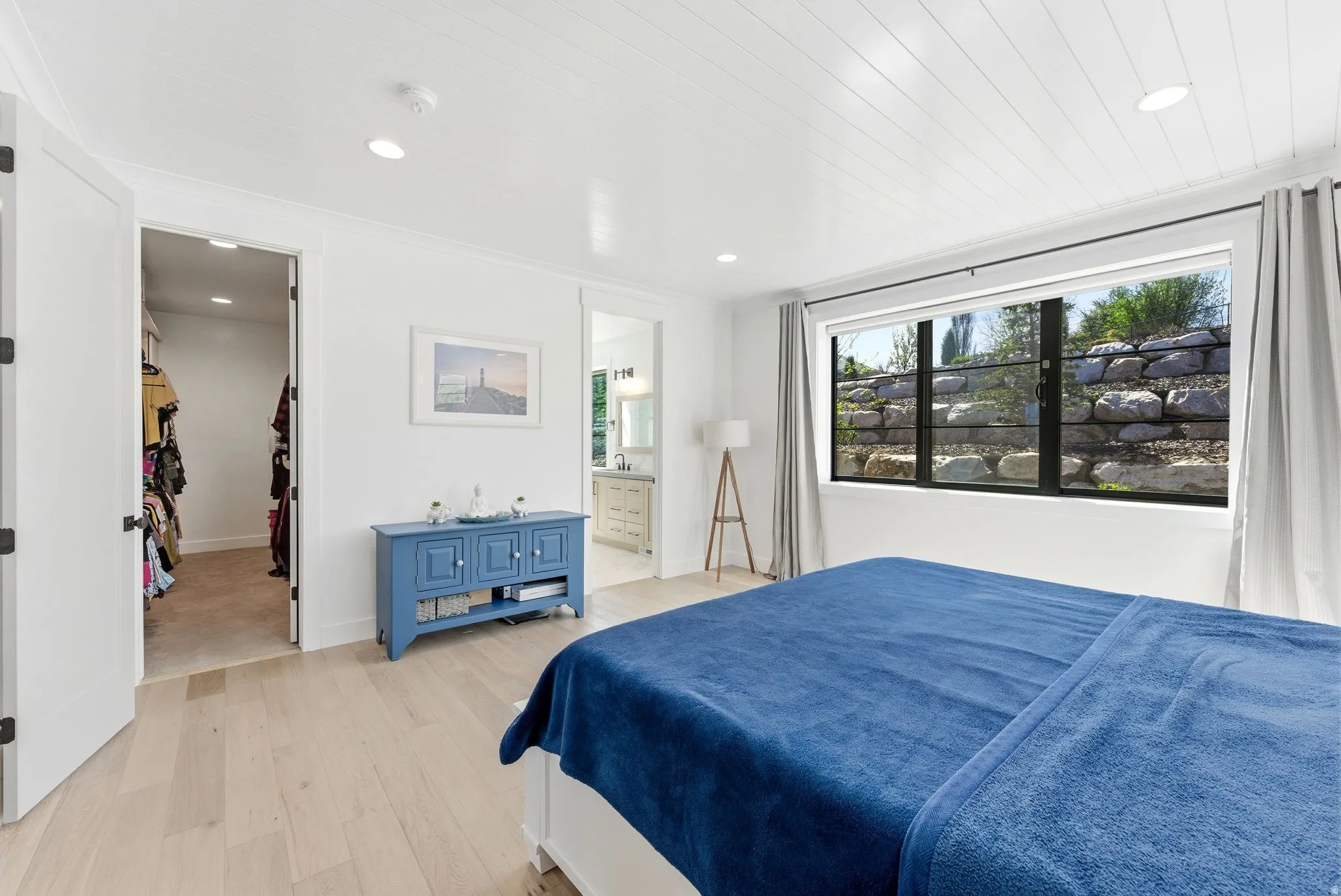 Primary Bedroom featuring light wood-type flooring, recessed lighting, ensuite bath, and a walk in closet with laundry hook ups