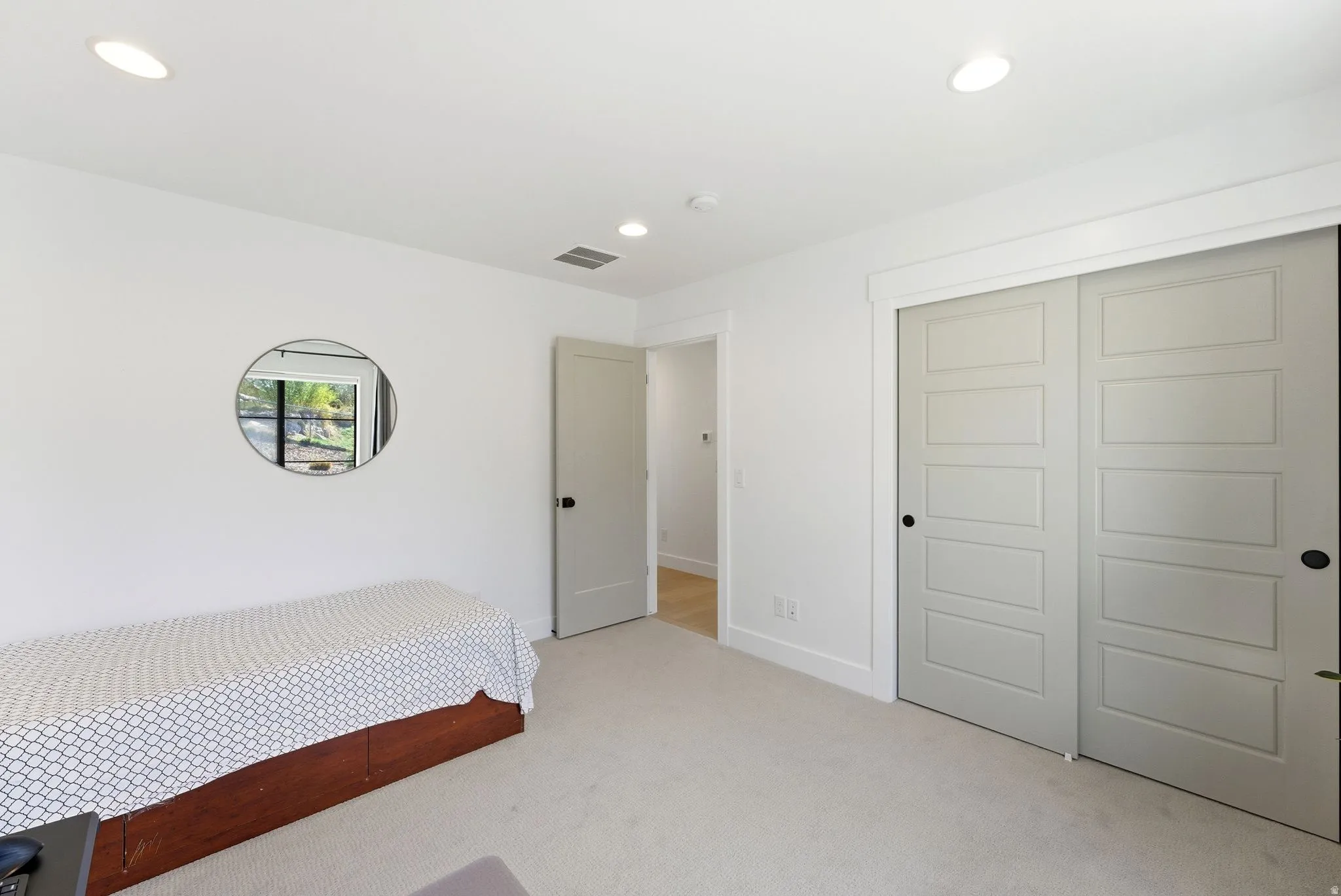 Bedroom used as an office with light colored carpet, a closet, and recessed lighting