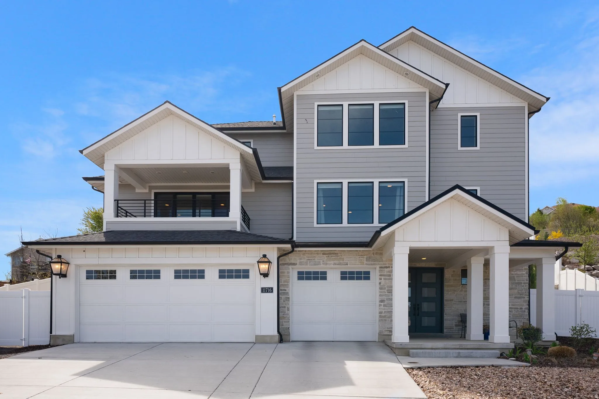 View of front of home featuring board and batten siding, a garage, stone siding, and concrete driveway